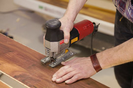 Fachmann schneidet beim Parkett verlegen Parkett zu